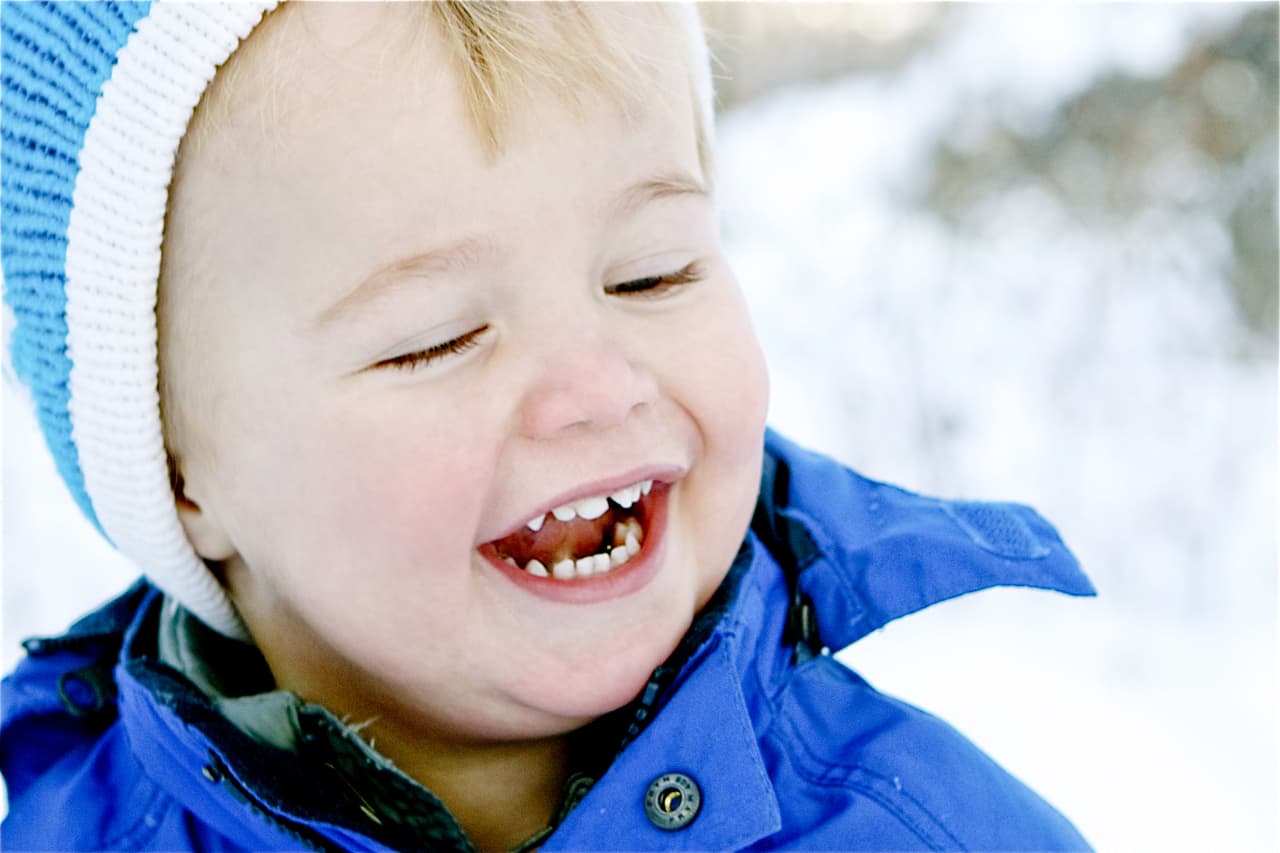 boy in blue coat in the snow photograph