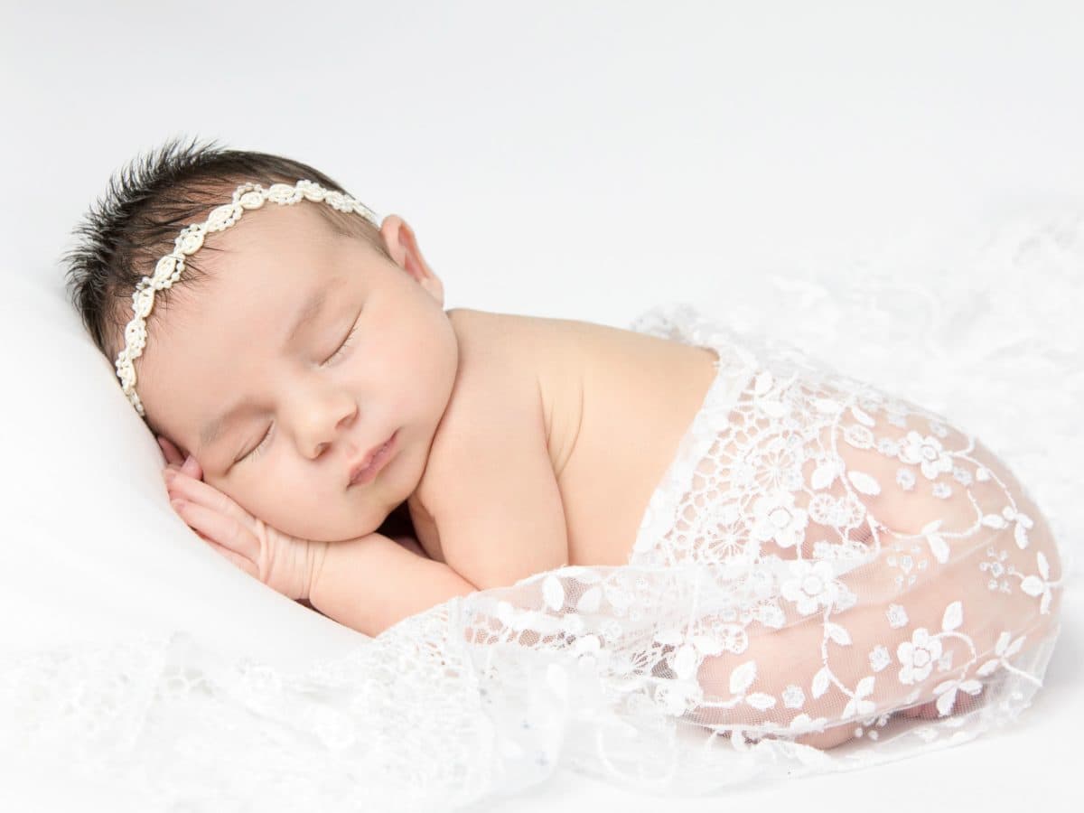 sleeping newborn with white lace and headband