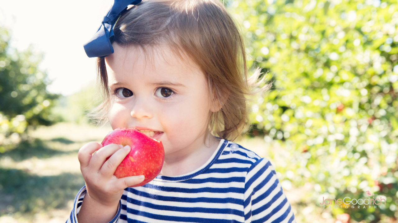 little girl eating apple how to photograph your kids digital course with Jane Goodrich