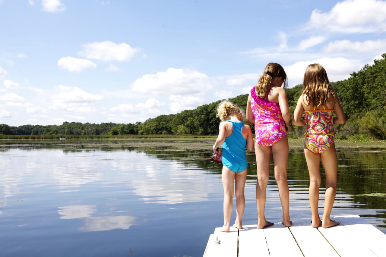 summer photo of sisters swimming on dock