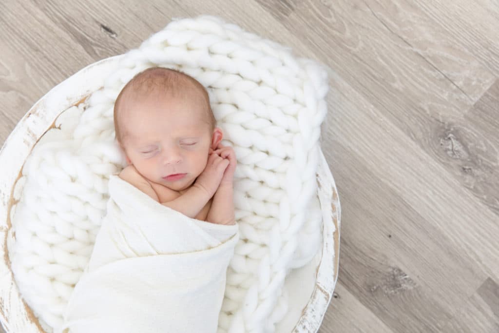 newborn baby on fluffy white blanket