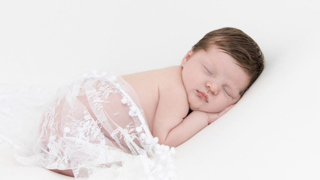 Image of newborn in white lace wrap during newborn photography shoot jane goodrich photography studio in larchmont, NY